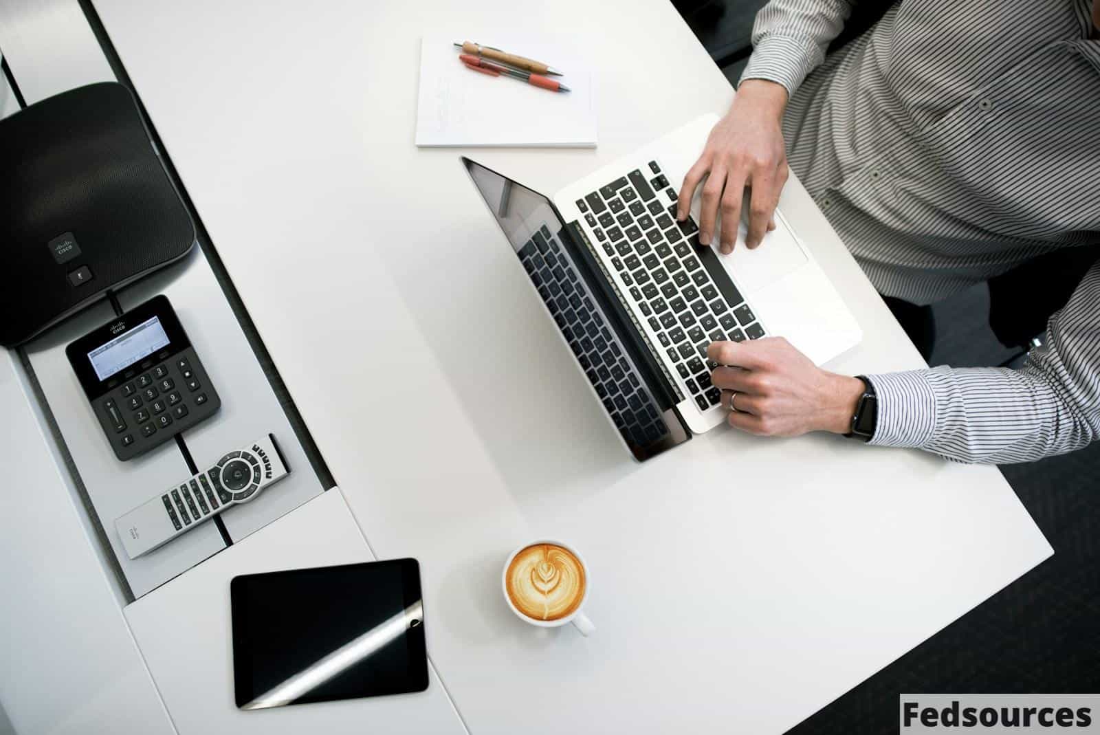 person using laptop on white wooden table