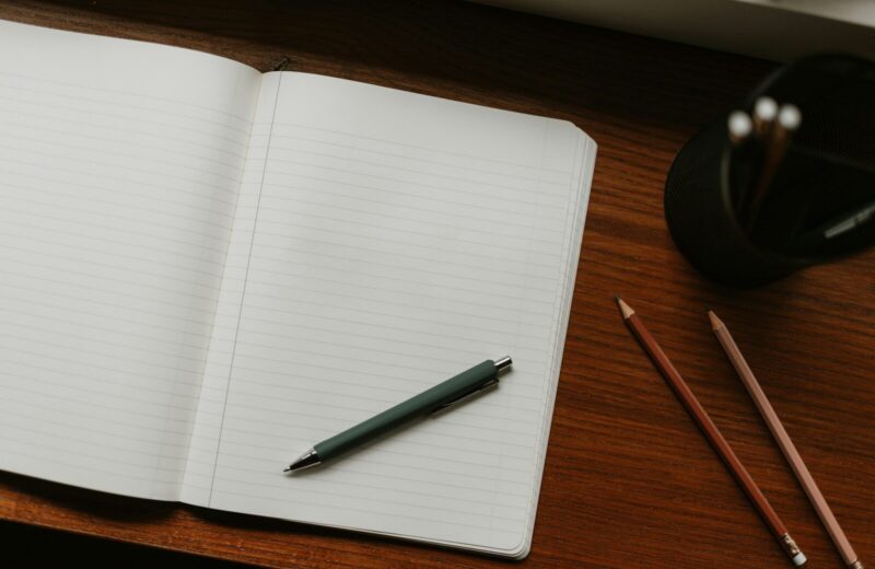 Libreta abierta con un bolígrafo sobre una mesa de madera